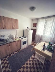 a kitchen with a stove and a refrigerator and a table at BGD apartman in Dušanovac (historical)