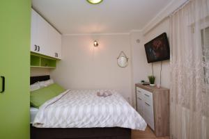 een kleine slaapkamer met een bed en een raam bij Memento in Kragujevac