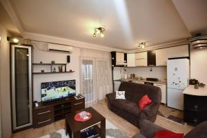 een woonkamer met een bank en een tv bij Memento in Kragujevac