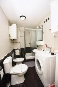 een badkamer met een toilet en een wasmachine bij Memento in Kragujevac