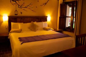 a bedroom with a large white bed with a window at Hotel San Marcos in San Cristóbal de Las Casas