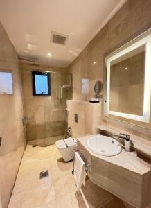 La salle de bains est pourvue d'un lavabo, de toilettes et d'une douche. dans l'établissement هوتيلتن قرطبه HOTELTEN Qurtubah, à Riyad