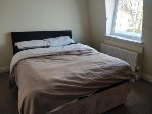 a large bed in a bedroom with a window at City Centre Room in Plymouth