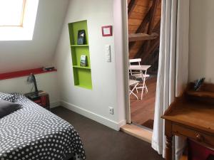 a bedroom with a bed and a staircase with a table at B&B Le Lodge in Bourgheim