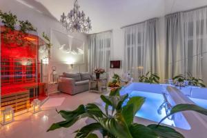 a bathroom with a tub in a room with a couch at Sensual Luxury SPA Suite Private Jacuzzi & Sauna for Couples in Poznań