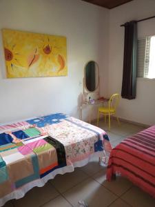 1 dormitorio con 1 cama y una pintura en la pared en Singela Casa em Chapada dos Guimarães en Chapada dos Guimarães