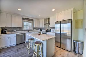 a kitchen with white cabinets and a large refrigerator at Portsmouth Waterfront Vacation Rental with Deck in Portsmouth