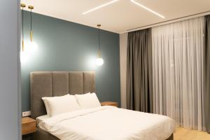 um quarto com uma cama e duas luzes pendentes em Budz Карпати em Bukovel