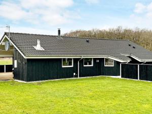 8 person holiday home in Storvorde في Egense: منزل أسود أمامه ساحة كبيرة