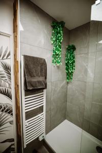 a bathroom with a shower with green plants on the wall at L'Échappée Parisienne - Canal St-Denis in Aubervilliers