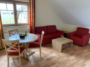 a living room with a red couch and a table at Laupus-Hof in Bad Vilbel