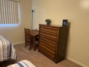 - une chambre avec une commode en bois, une table et une chaise dans l'établissement Verndale Apartment, à Salt Lake City