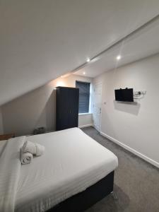 sypialnia z łóżkiem i telewizorem na ścianie w obiekcie APARTMENT in BARNSLEY CENTRAL w mieście Barnsley