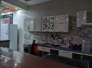a kitchen with white cabinets and a counter top at شاليه بالريف الاوربي للاجازات in Giza