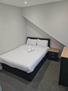 巴恩斯利APARTMENT in BARNSLEY CENTRAL的房间里有一张铺着白色床单和枕头的床