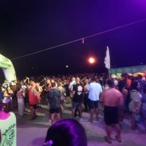 un gran grupo de personas de pie en una multitud por la noche en Haadrin Village near the pier, en Haad Rin