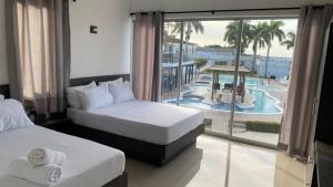 a hotel room with two beds and a view of a pool at Hotel Castillo del Mar in Ríohacha +97 photos