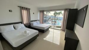 a bedroom with two beds and a view of a pool at Hotel Castillo del Mar in Ríohacha