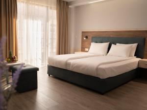 a bedroom with a large bed and a large window at Guest House Velik in Sandanski