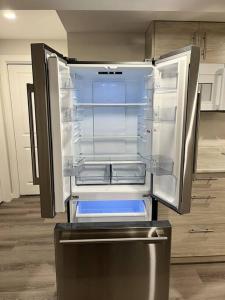 an empty refrigerator with its door open in a kitchen at Cozy Private 1 bedroom basement suite - free parking and free Wifi in Winnipeg