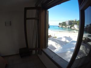 a room with a window with a view of a beach at Hostal Playa in Cala Santanyi