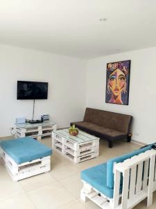a living room with a couch and a tv at Casa en Playa Privada - A pocos minutos de General Villamil Playas in Posorja