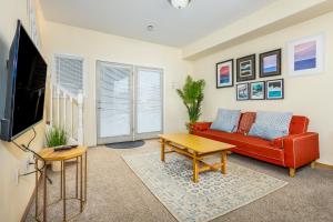 a living room with a red couch and a tv at Harmony Hills #229 in Anchorage