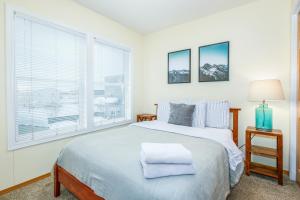 a white bedroom with a large bed and a window at Harmony Hills #229 in Anchorage