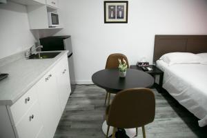 a room with a sink and a table and a bed at Westview Centre Motel in Powell River