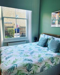 a bedroom with a bed with a leaf pattern on it at By the Pagoda- cozy garden flat by Richmond & Kew Gardens in Kew Gardens