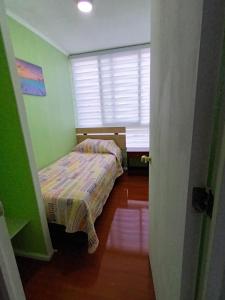 a small bedroom with a bed and a window at Apartamento in Los Andes