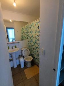 uma casa de banho com um lavatório, um WC e um espelho. em Apartamento em Los Andes