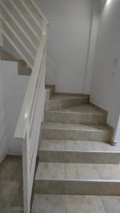 a staircase in a house with white walls and stone floors at SOL Y RÍO in Colón