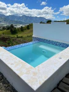 uma piscina com água azul no topo de um edifício em La Casita de Charo 2 em Constanza