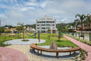 um parque com um parque infantil com um banco e um baloiço em Cannes Club Residence a 200m da praia, recém inaugurado em Florianópolis