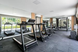 a gym with several tread machines and a mirror at Cannes Club by Viva - Residencial a 200m da praia Ingleses do Rio Vermelho in Florianópolis