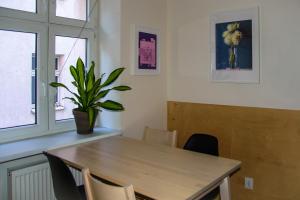 uma sala de jantar com uma mesa de madeira e um vaso de plantas em Milo Mi - 2 Bedroom Apartment in the Old Town em Poznań