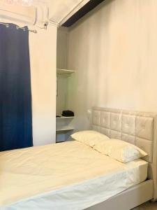 um quarto com uma cama branca e uma cortina azul em Centrico Apartamento Barrio de La Exposición na Cidade do Panamá