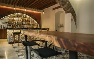 - un bar avec une grande table et des chaises dans la chambre dans l'établissement Casa Azulai Puebla Hotel Boutique, à Puebla