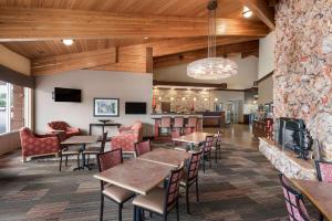 uma sala de jantar com mesas e cadeiras e uma lareira em Best Western Plus Cedar City em Cedar City