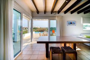 a dining room with a table and views of the patio at Villa Mercedes in Cala Morell