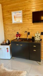 a kitchen with a black counter and a sink at Cabanas Kuntze in Urubici