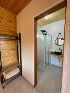 a bathroom with a shower and a glass door at Cabanas Kuntze in Urubici