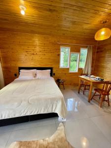 1 dormitorio con 1 cama y pared de madera en Cabanas Kuntze, en Urubici