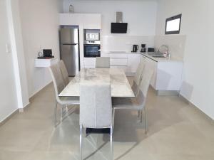 a white kitchen with a table and chairs in it at Villa Sunset Avenue in Paul do Mar