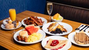 a table topped with plates of breakfast foods and drinks at Excalibur in Las Vegas