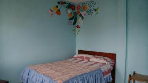 a bedroom with a bed with a flower mural on the wall at Zumag Sisa in Tena