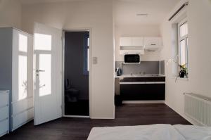 a white room with a kitchen and a bed at Apartmány Centrum in Nový Bor