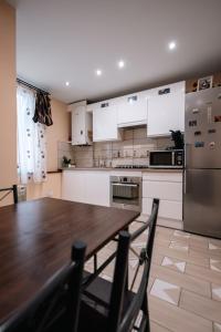 eine Küche mit einem Holztisch und einem Kühlschrank in der Unterkunft La Sérénité Urbaine in Bischheim