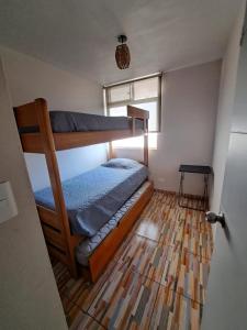 1 dormitorio con litera y suelo de madera en Departamento La Serena, en La Serena